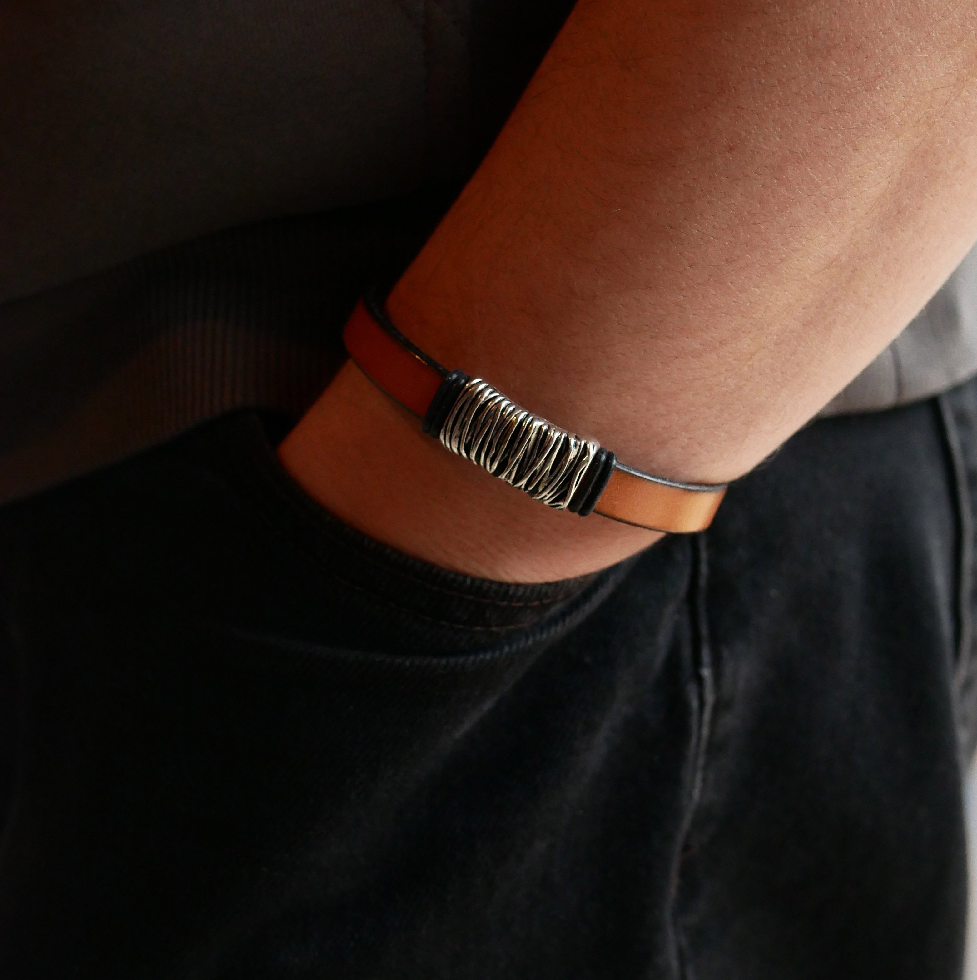 Bracelete em pele camel com decoração em metal entrançado e fecho em forma de T
