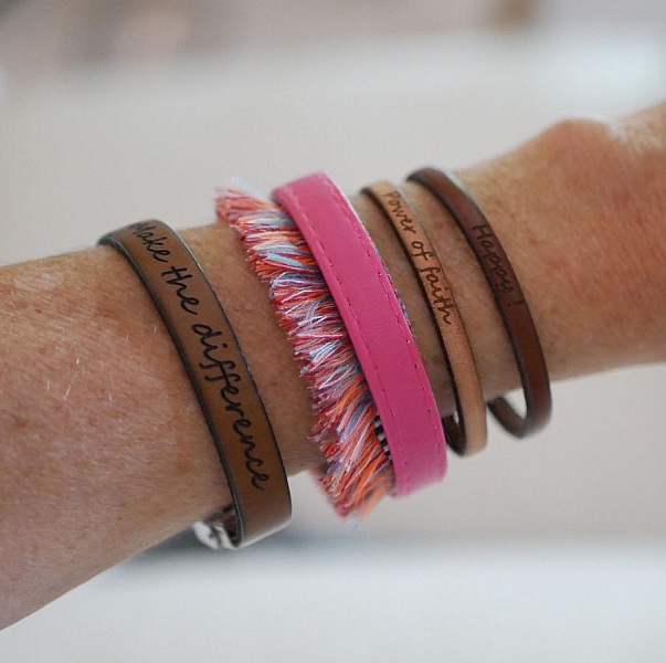 Bracelets femme personnalisables en cuir fin empilés au poignet.