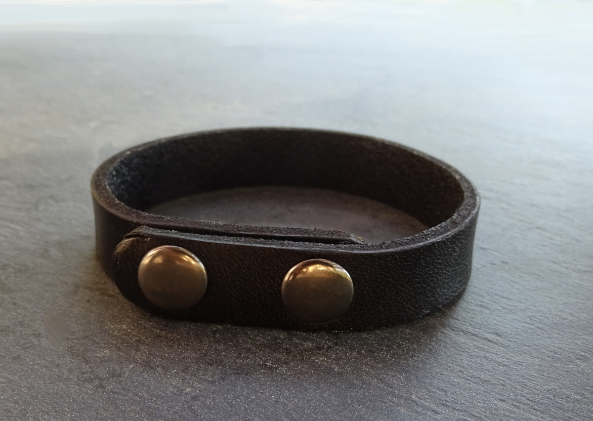 Bracelete em pele mista preta gravada com botões de pressão