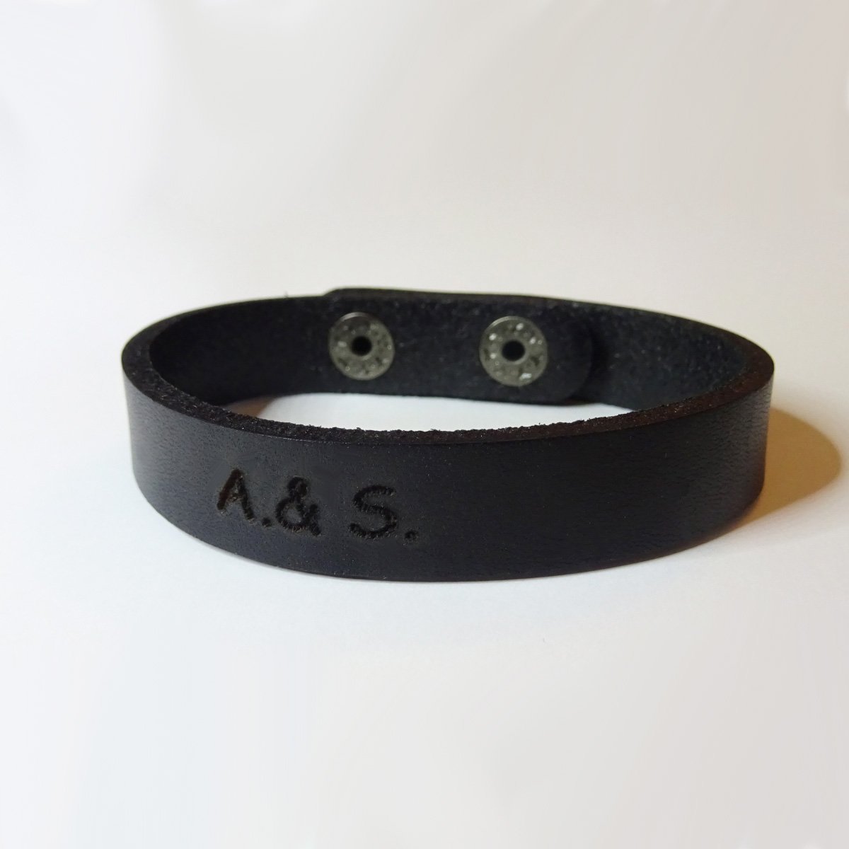 Bracelete em pele mista preta gravada com botões de pressão