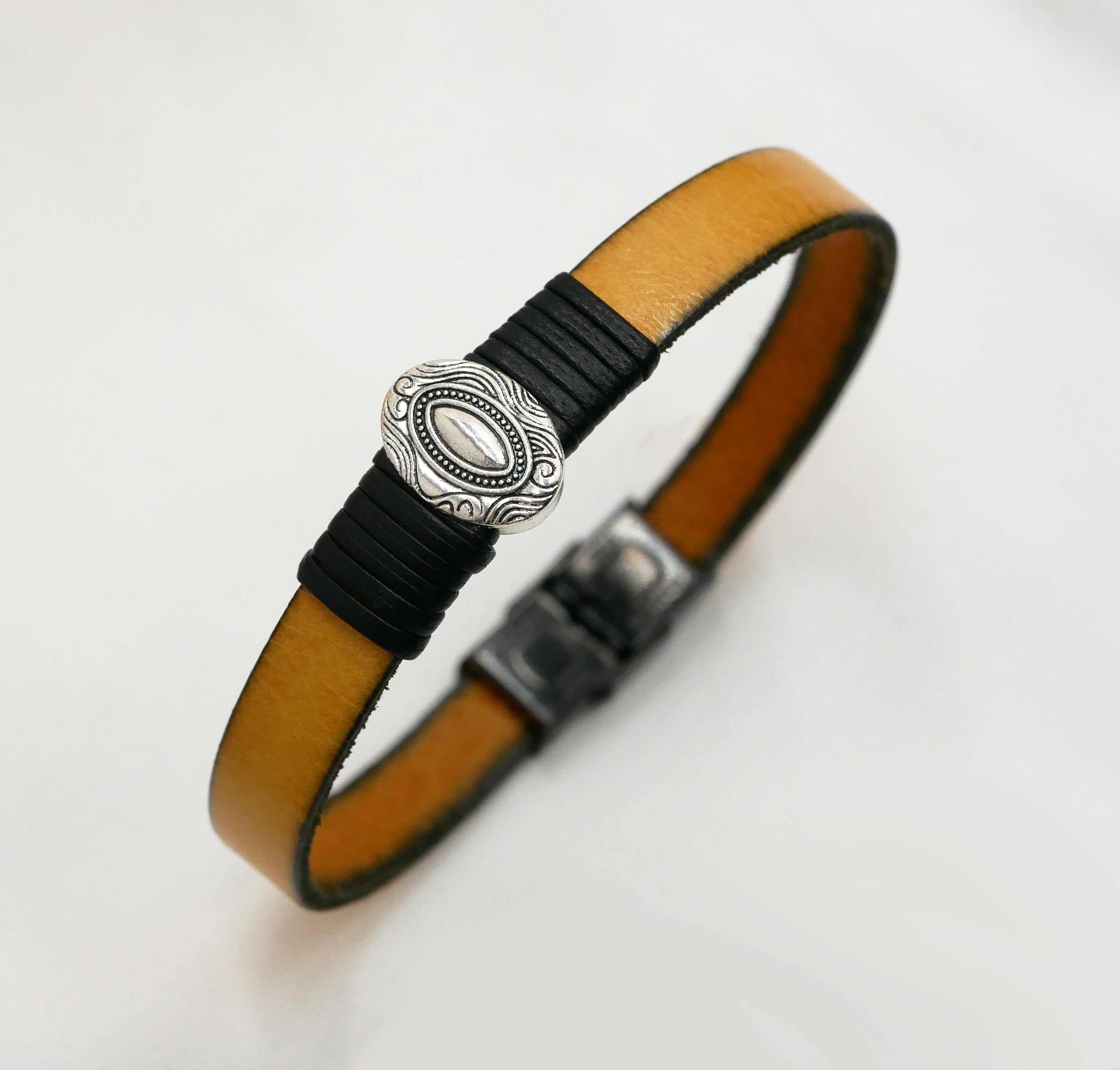 Bracelete em pele personalizável com ornamento oval central emoldurado por peles finas 