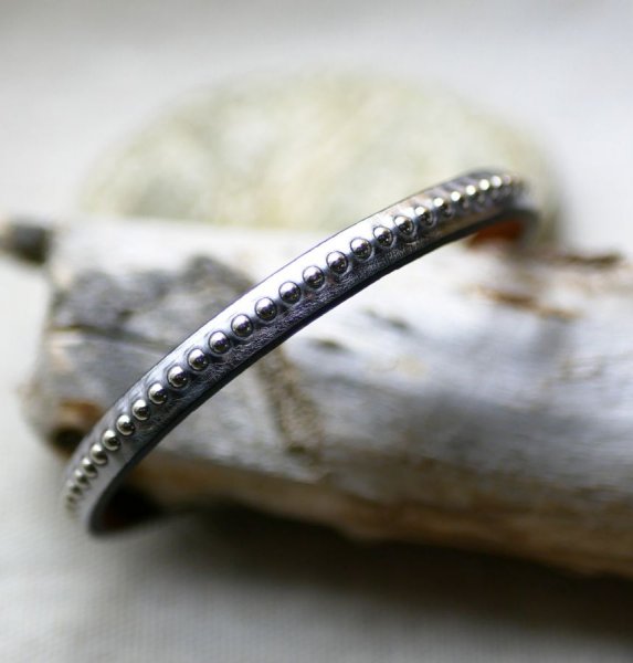 Pulseira feminina em couro met&aacute;lico cinzento escuro com missangas prateadas 