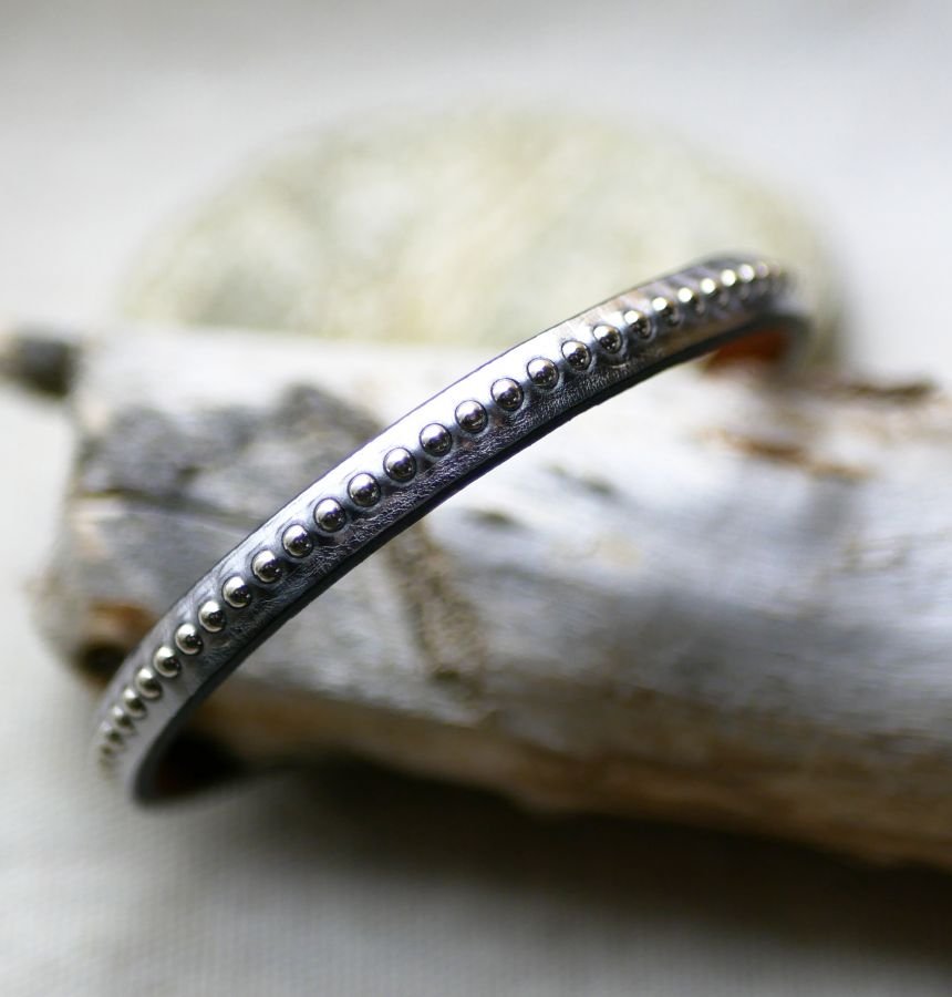 Pulseira feminina em couro metálico cinzento escuro com missangas prateadas 