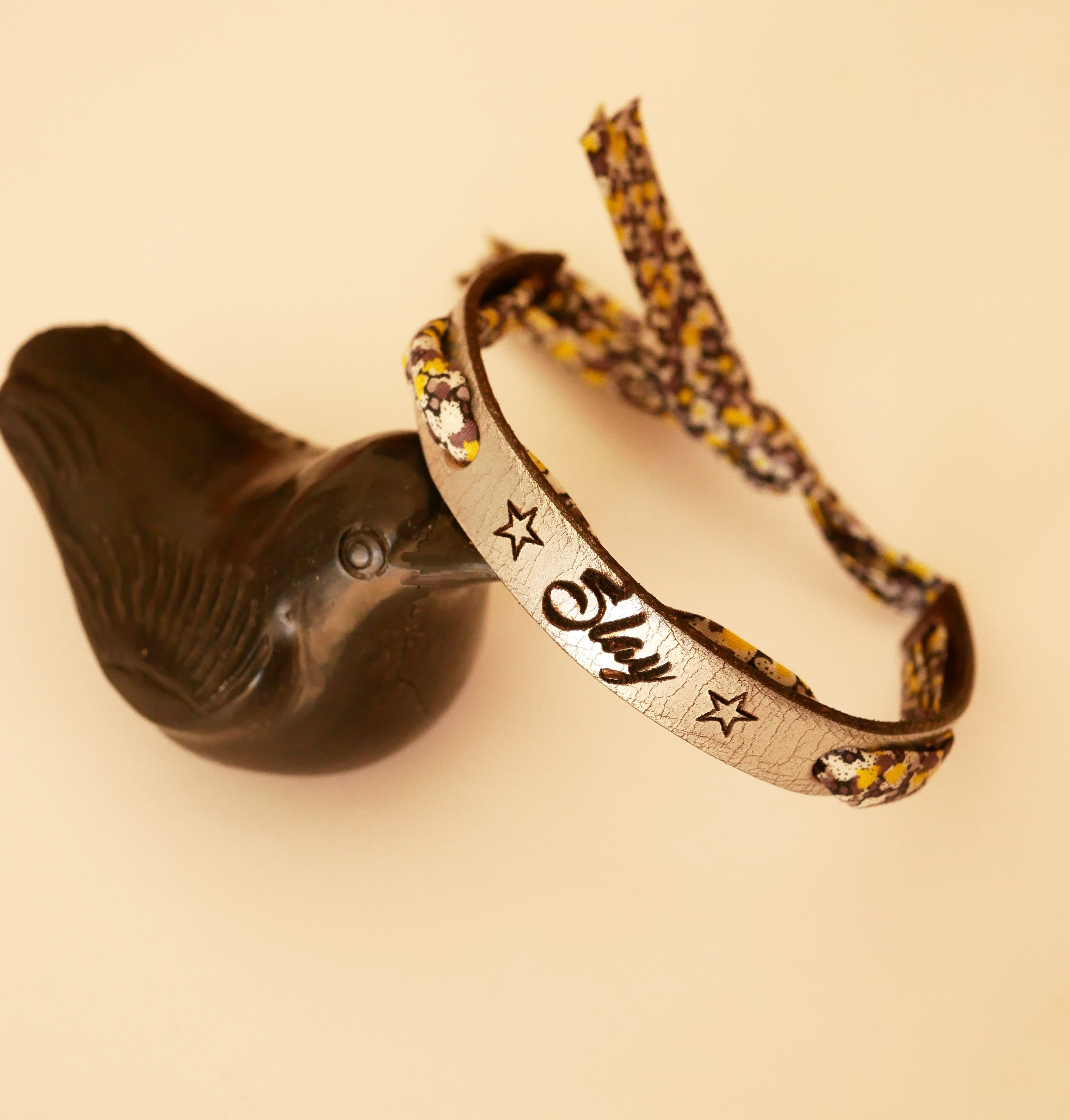 Pulseira Florâme gravada com flores amarelas em fita liberty em pele prateada