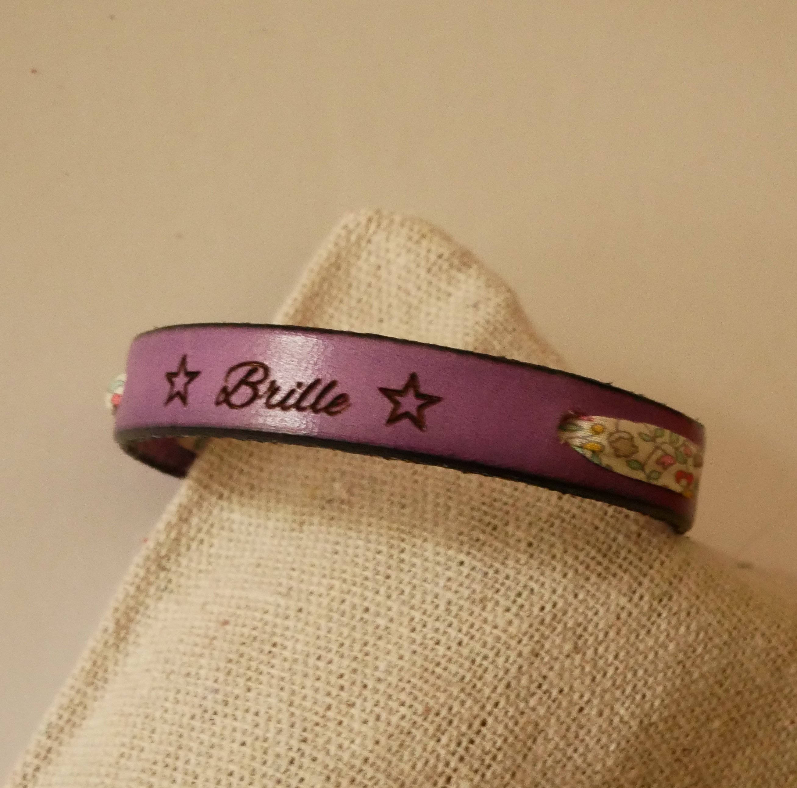 Pulseira Florâme "Brille" gravada com fita liberty em tons pastel sobre pele roxa