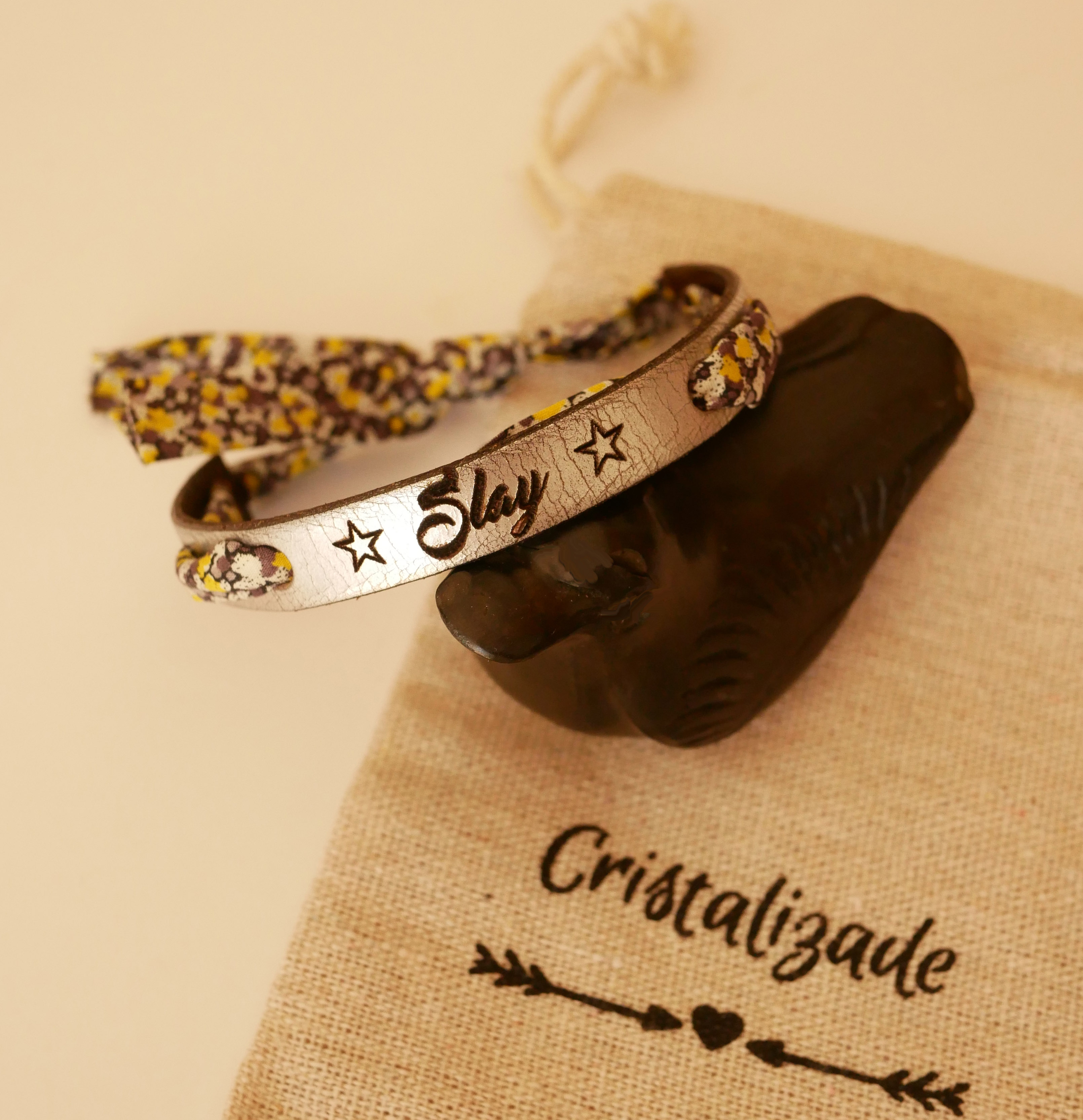 Pulseira Florâme gravada com flores amarelas em fita liberty em pele prateada