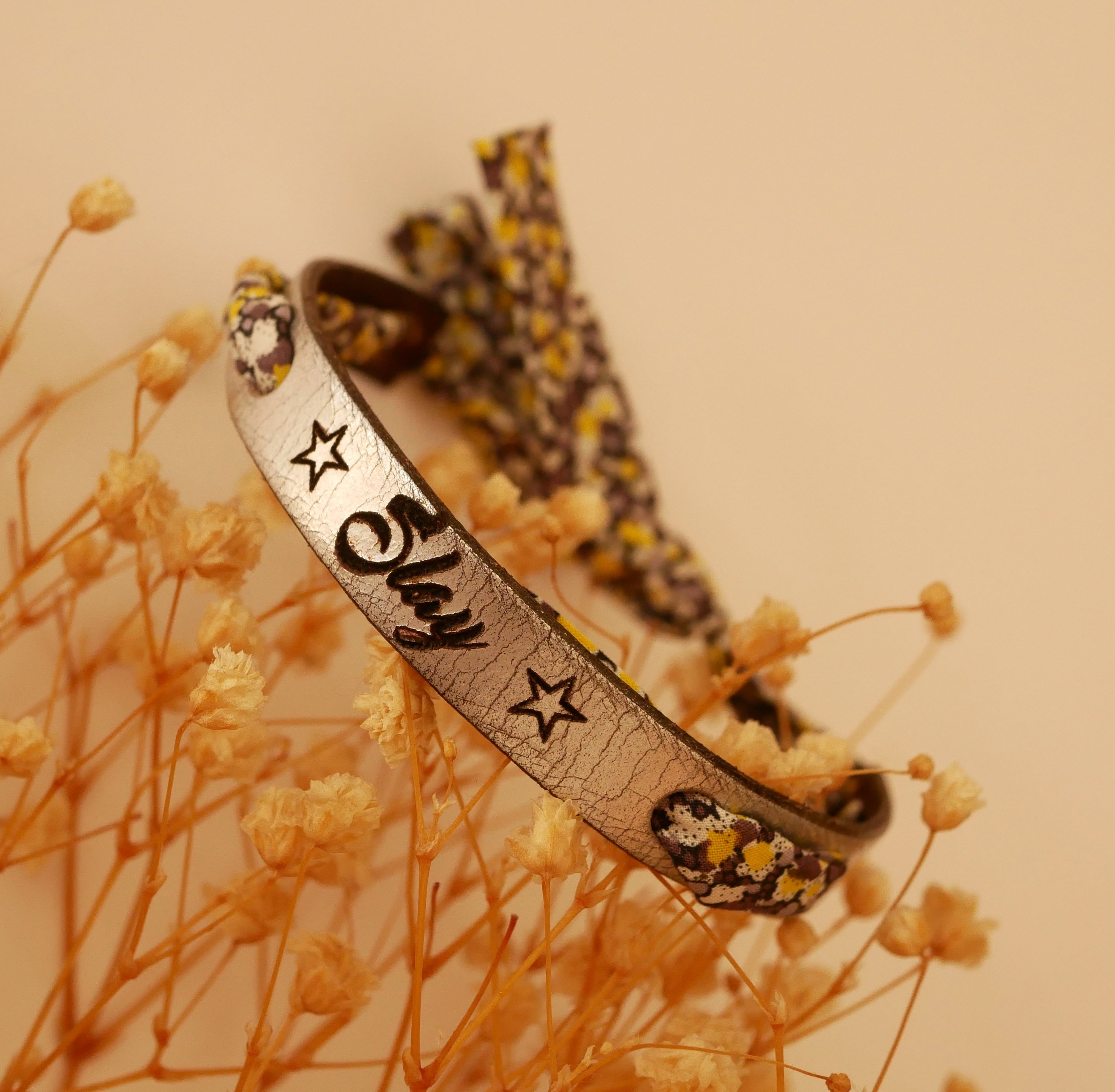 Pulseira Florâme gravada com flores amarelas em fita liberty em pele prateada