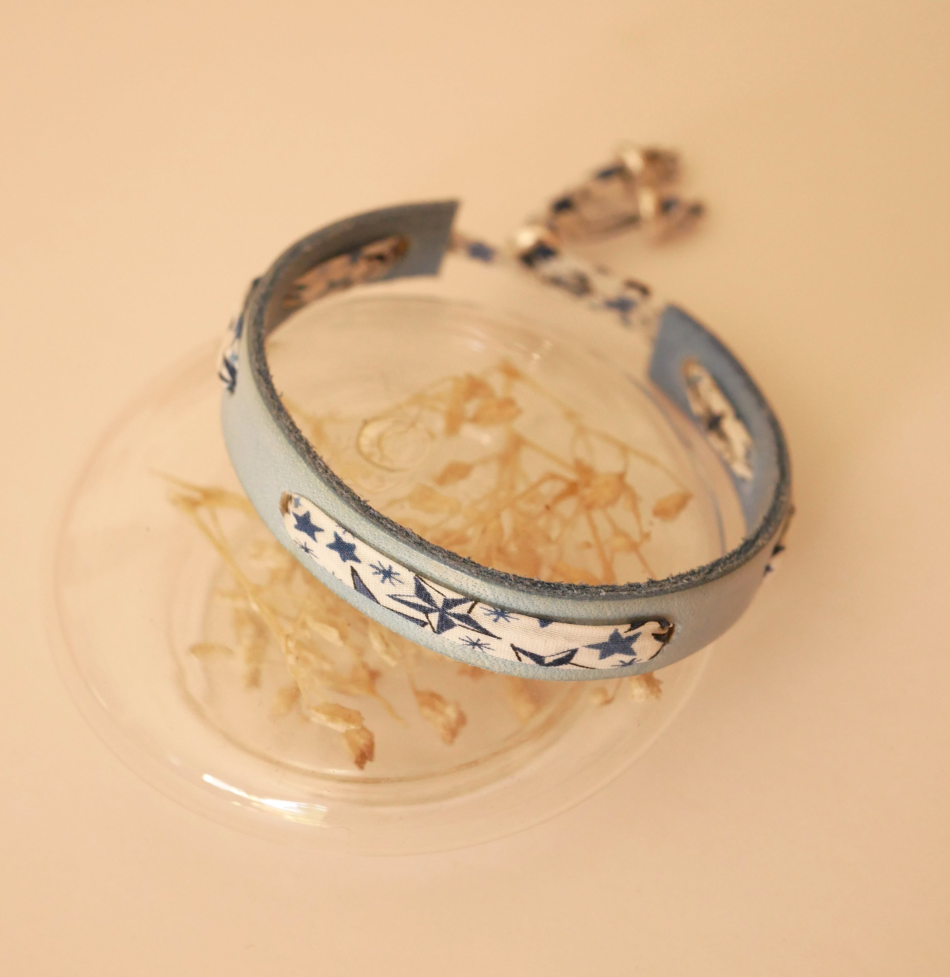 Pulseira Flor&acirc;me com fita liberty e estrelas azuis em pele celeste