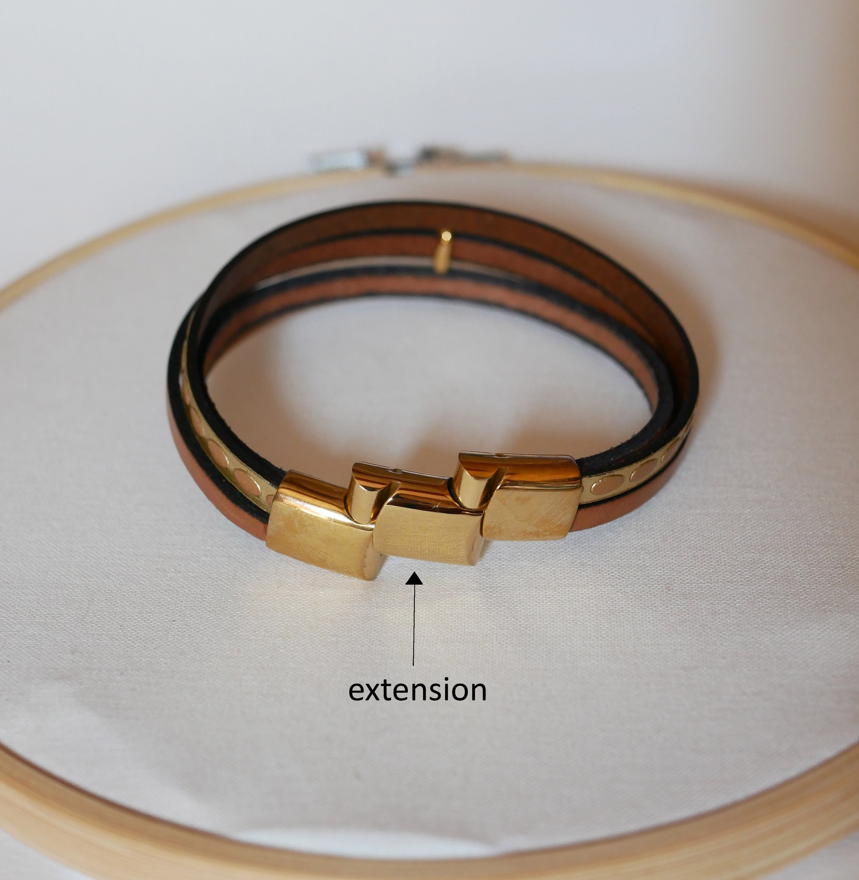 Pulseira de couro com v&aacute;rios elos e la&ccedil;o dourado com raios de sol