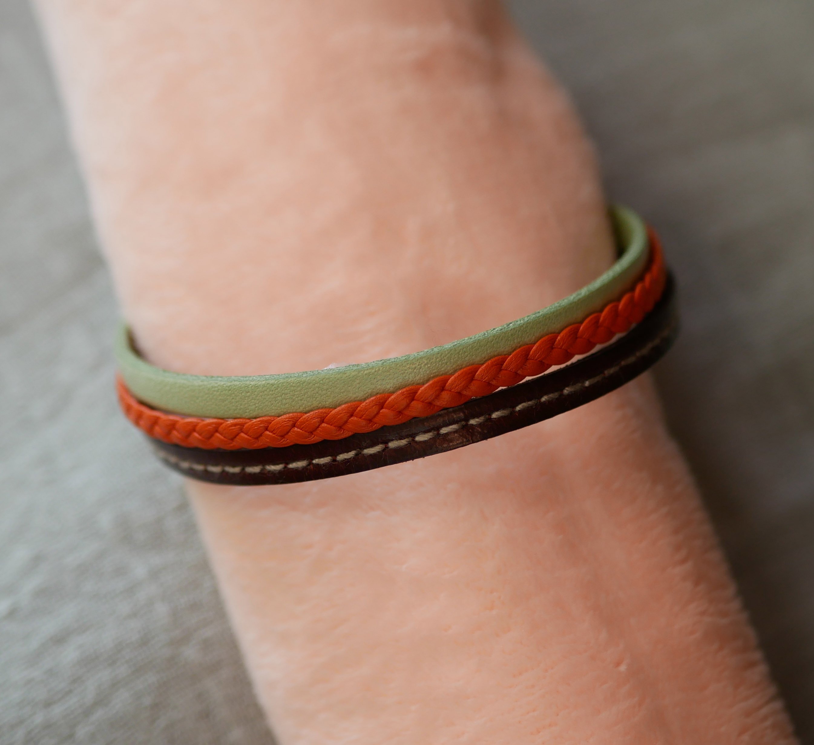 Pulseira de punho em pele múltipla com amêndoa, trança laranja e costura bordeaux
