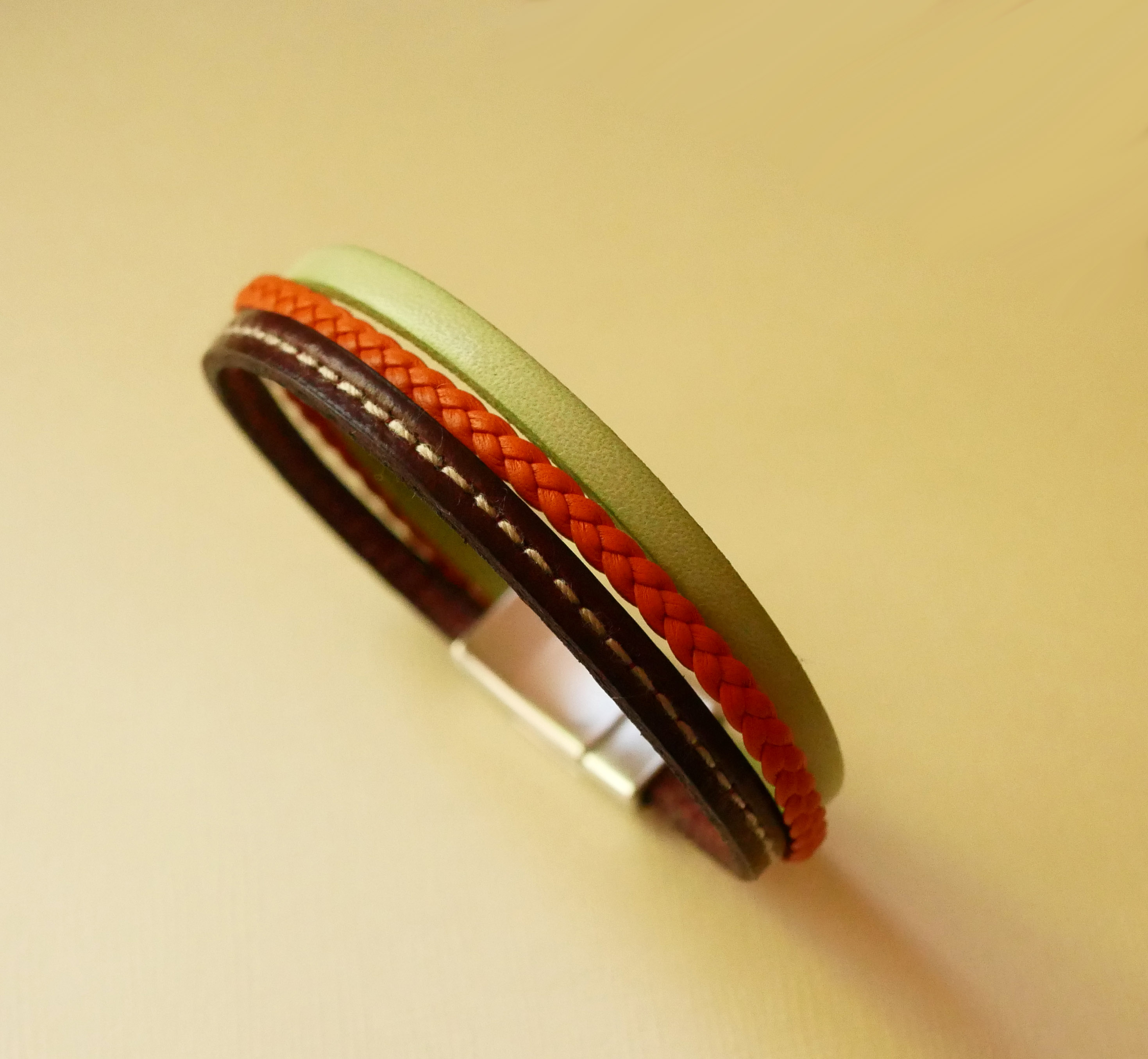 Pulseira de punho em pele múltipla com amêndoa, trança laranja e costura bordeaux