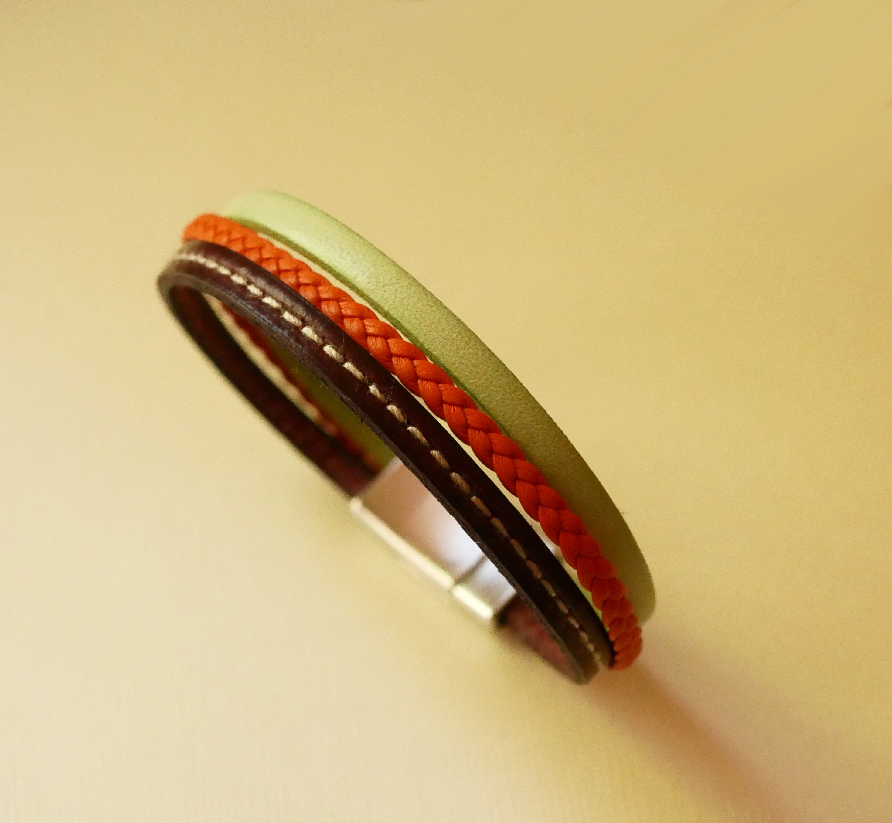 Pulseira de punho em pele m&uacute;ltipla com am&ecirc;ndoa, tran&ccedil;a laranja e costura bordeaux