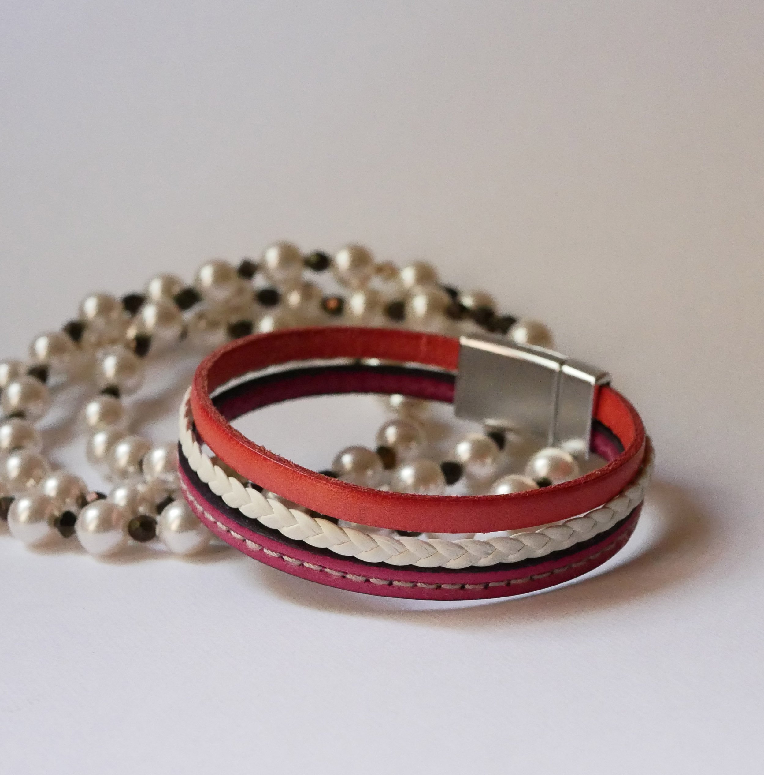 Pulseira de punho entrançado em pele branca e coral