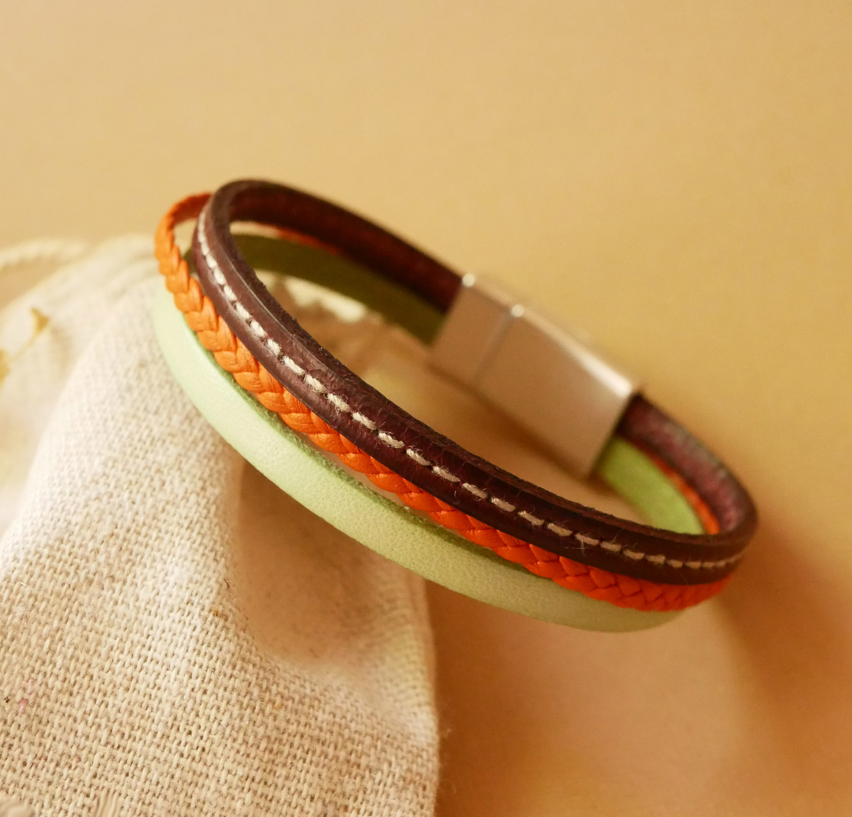 Pulseira de punho em pele múltipla com amêndoa, trança laranja e costura bordeaux