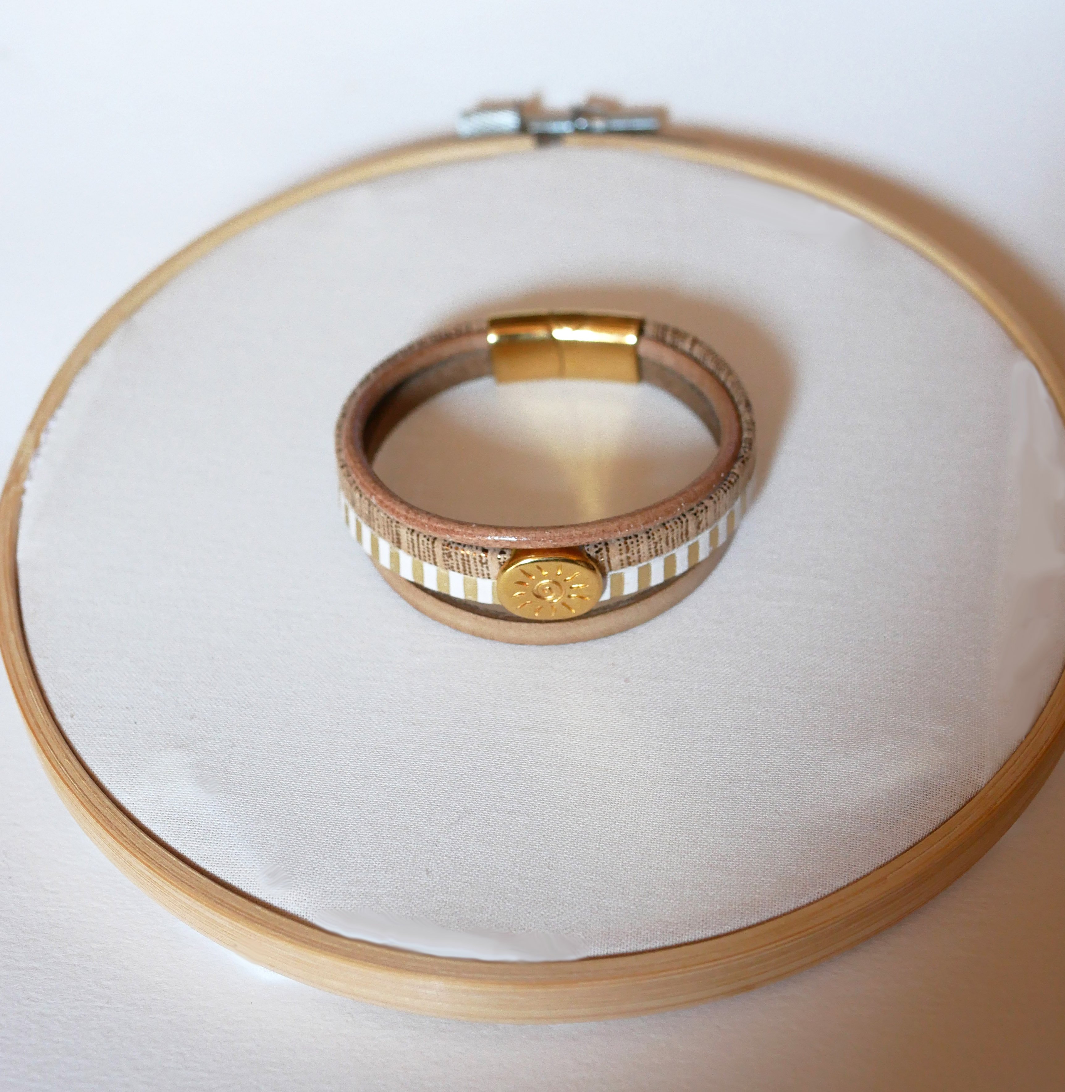 Pulseira de couro com v&aacute;rios elos e la&ccedil;o dourado com raios de sol