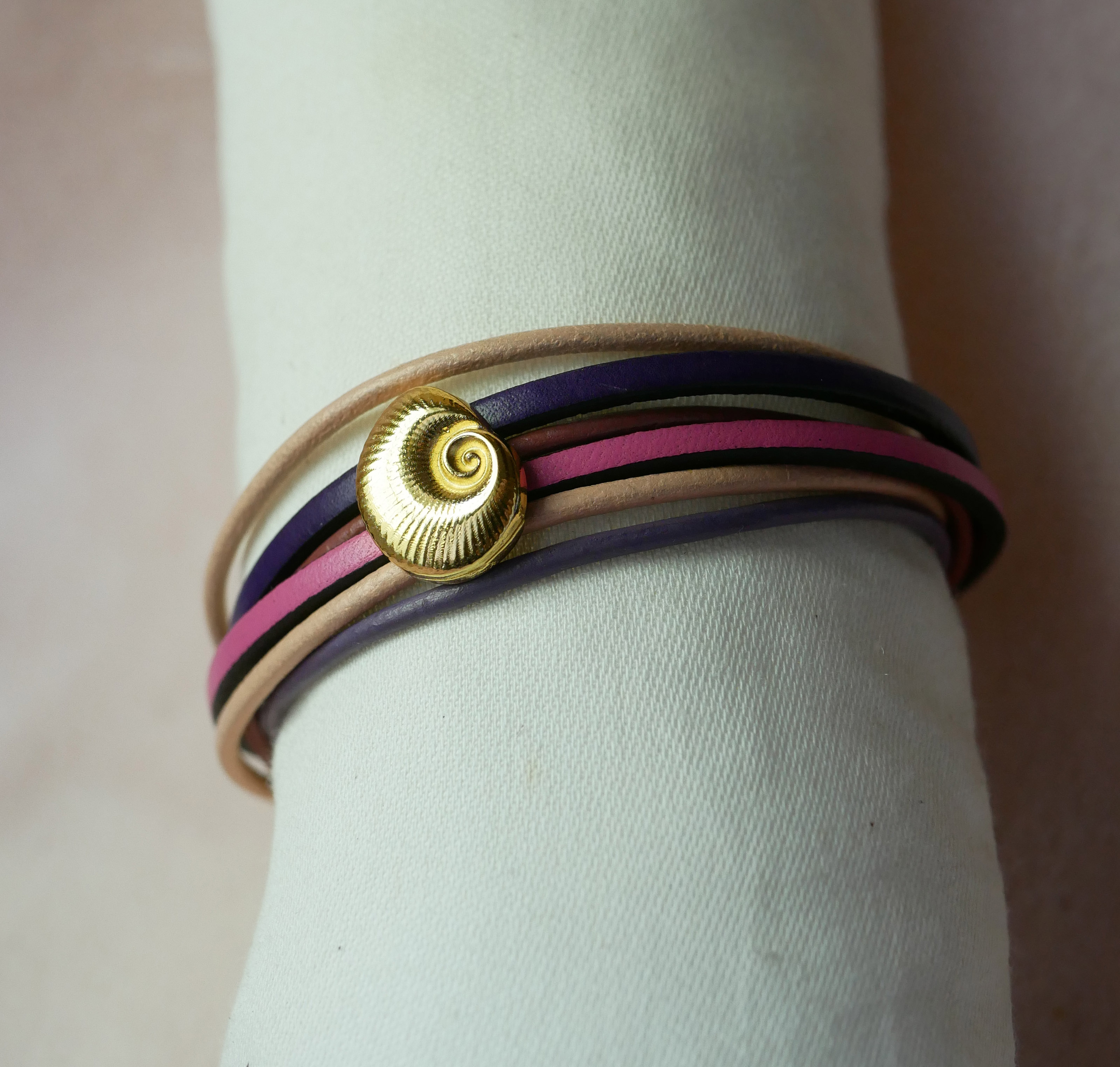 Pulseira com vários elos em pele de pêssego e malva com decoração de conchas douradas