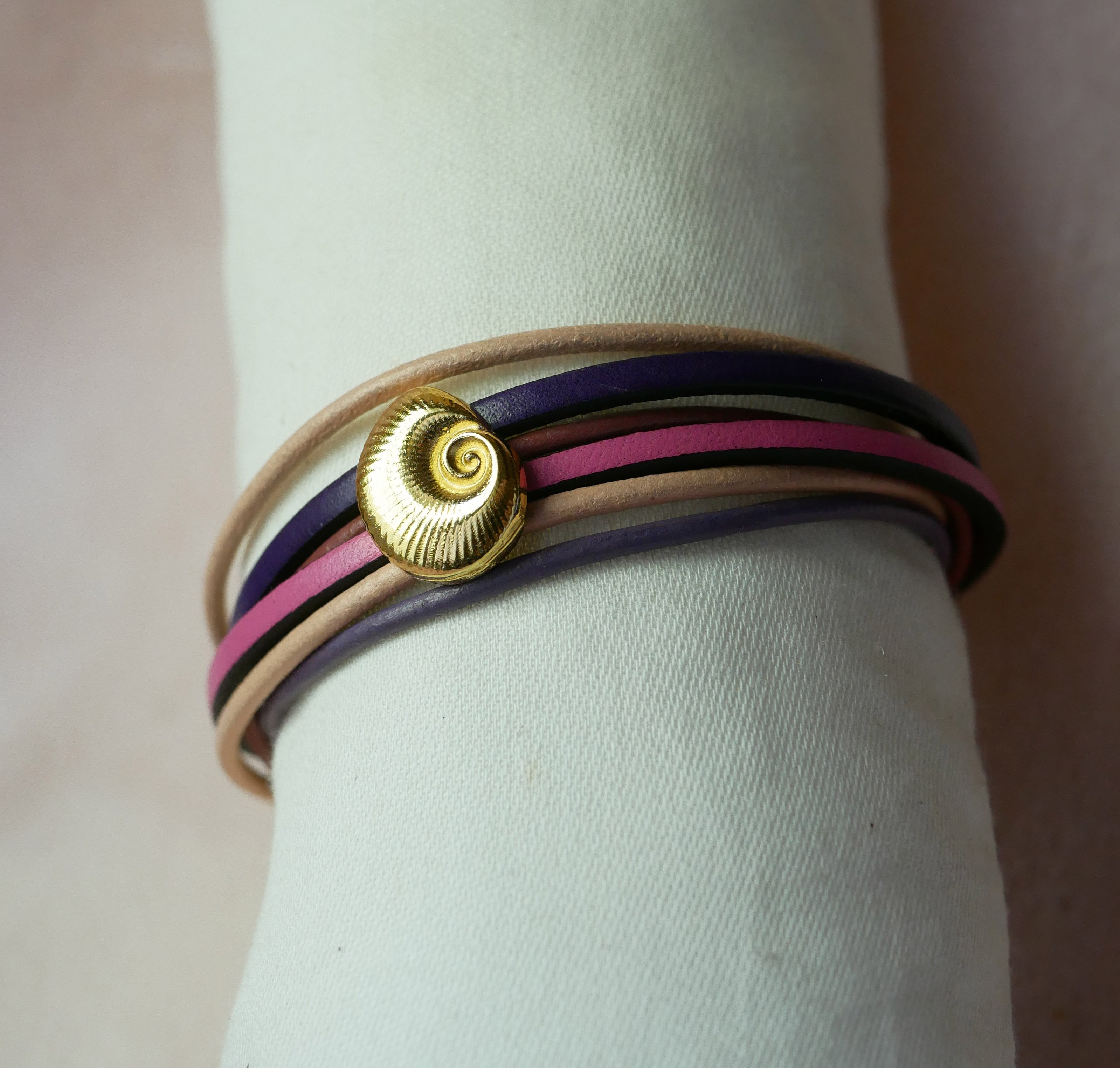 Pulseira com vários elos em pele de pêssego e malva com decoração de conchas douradas