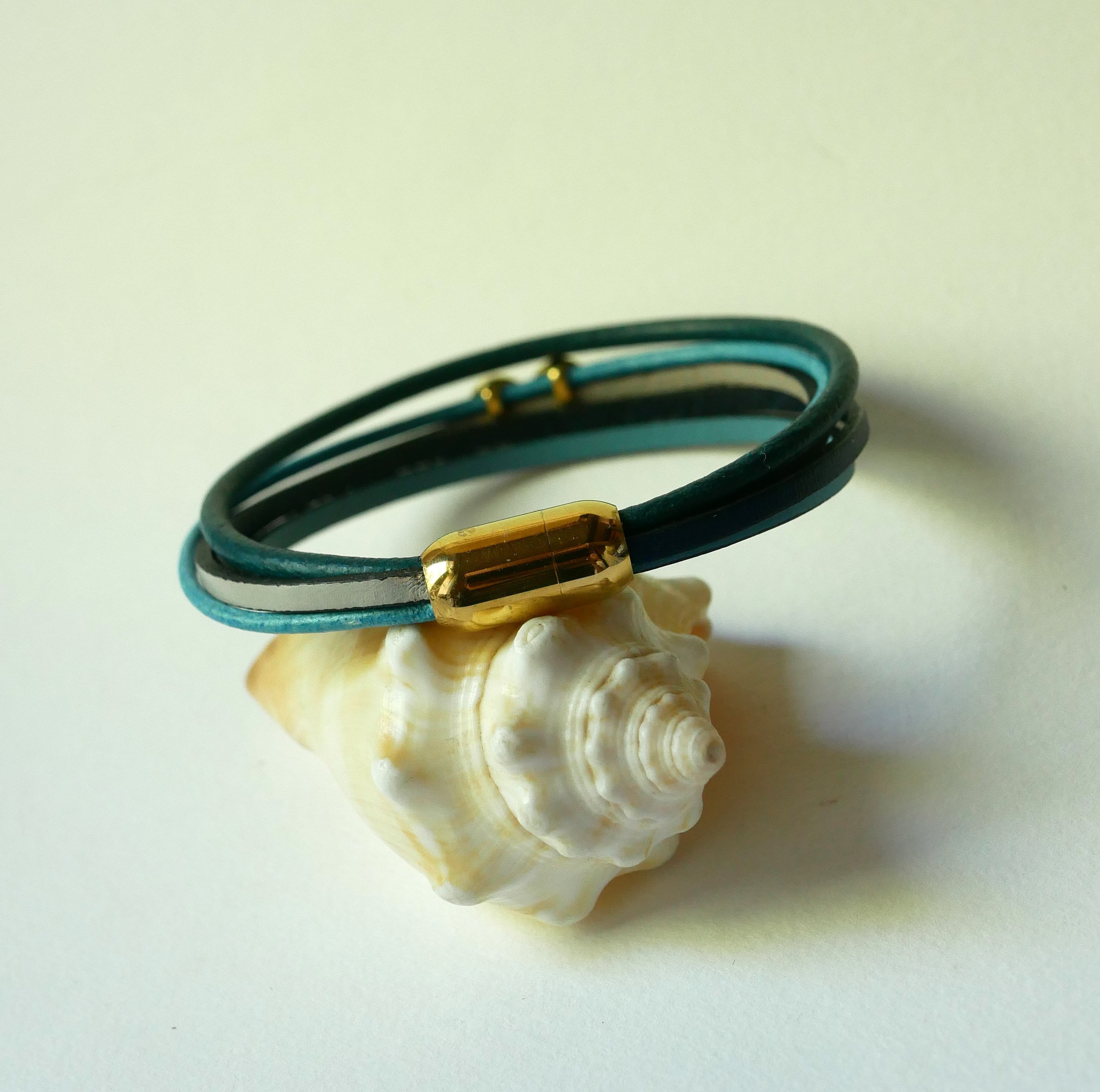 Pulseira com vários elos em pele azulada com motivo infinito dourado