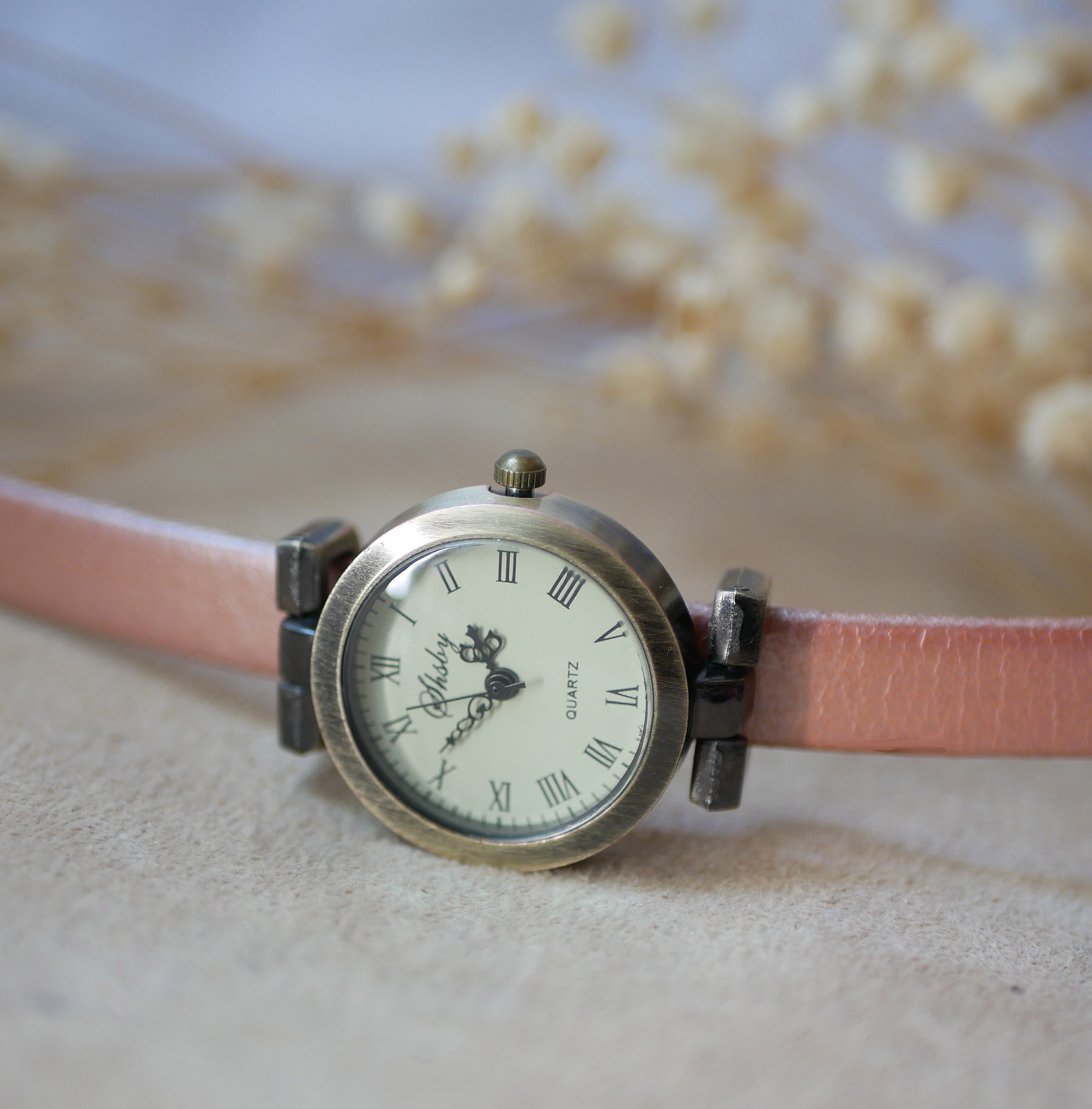 Cadran de montre vintage en bronze avec chiffres romains.