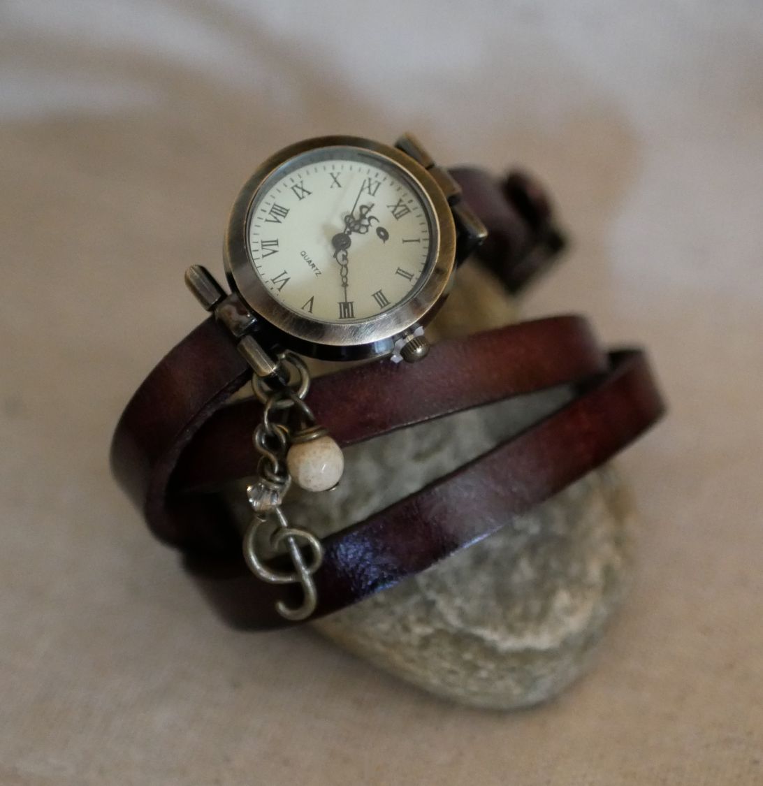 Relógio bracelete de couro com encantos de penas e pérolas