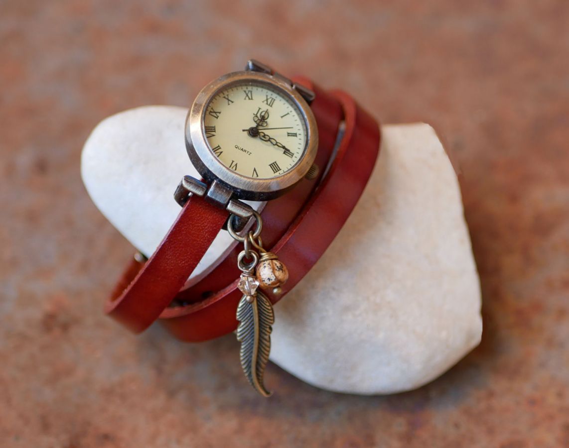 Relógio bracelete de couro com encantos de penas e pérolas