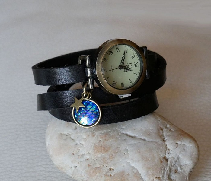 Montre bracelet cuir noir avec cabochon écailles bleues.