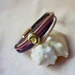 Pulseira com vários elos em pele de pêssego e malva com decoração de conchas douradas