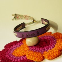 Pulseira Florâme "Brille" gravada com fita liberty em tons pastel sobre pele roxa